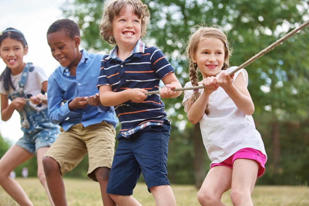 Group of kids pulling a rope while playing tug of war