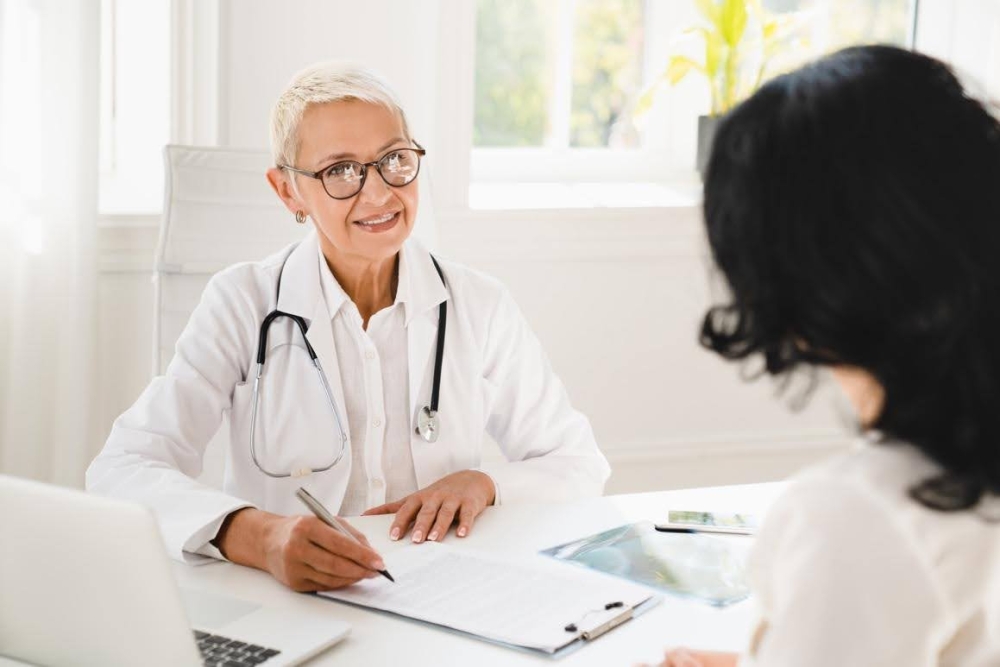 Allergist talking to a patient and writing on a clipboard