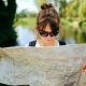 Woman outside wearing sunglasses and reading a map